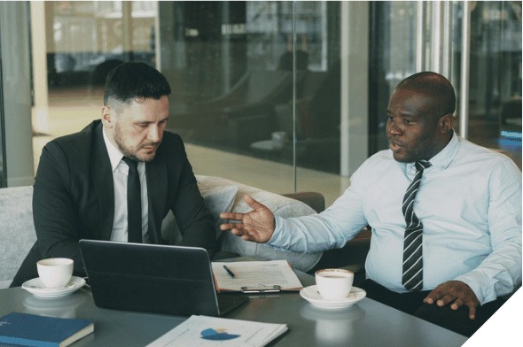 Two colleagues discussing investment documents in an office