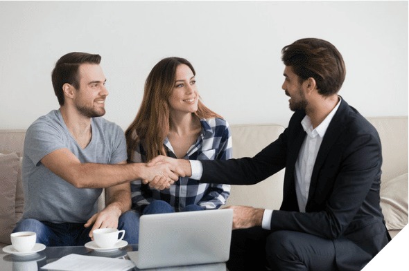 A couple shaking hands with their real estate agent